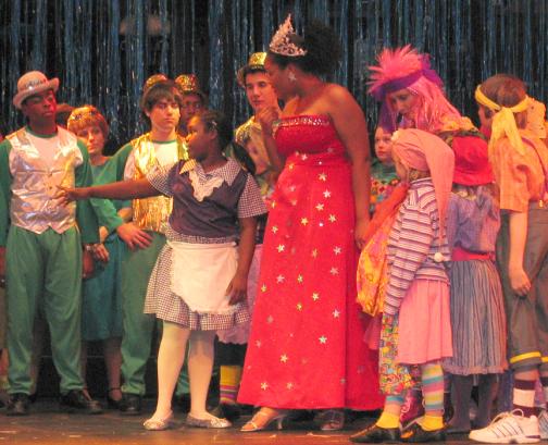Dorothy (Tatiana J. Lofton) gets some good advice from the Munchkins and the good witches of Oz  Glinda (Jne Williams, in red) and Addaperle (Gerri Weagraff, pink hair).